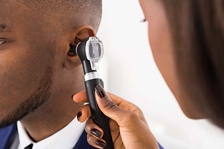 An Audiologist checking a patients ear