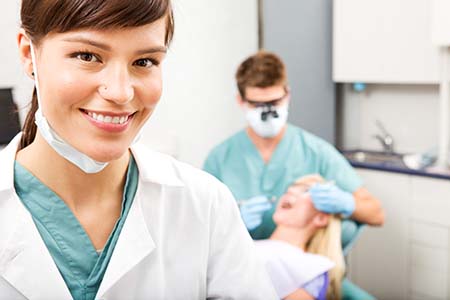 Dental hygienist confidently working, knowingly covered by medical malpractice insurance. 