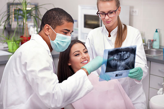 Dental nurse at work, helping the dentist with a patient