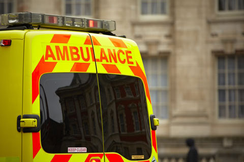 paramedic assisting patient in ambulance